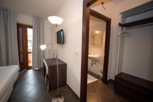 ein Hotelzimmer mit einem Bett und einem Bad mit einem Spiegel in der Unterkunft CONDOMINIO I GELSI in Arezzo