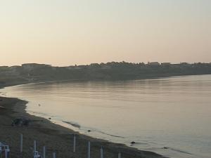 Suite Bice In Villaggio Seleno في Ovile la Marinella: اطلالة على جسم مائي مع شاطئ