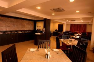a dining room with tables and chairs in a restaurant at Nagarjuna Suites in Bangalore