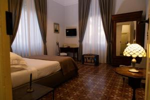 a bedroom with a bed and a table with a lamp at Villa Giordanelli in Scalea