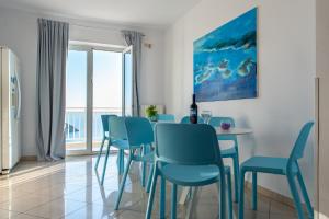 a dining room with blue chairs and a table at Rooms Raič in Dubrovnik