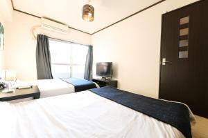 a hotel room with two beds and a window at H2O Stay Kikukawa Woody Sunheim #201 in Tokyo