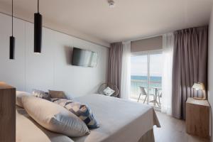 a hotel room with a bed and a balcony at Hotel Maritim in Roses
