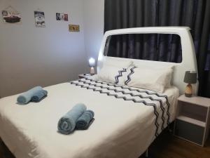 a bedroom with a white bed with blue towels on it at The V8 House in Sutherland