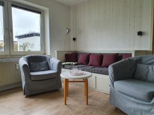 a living room with a couch and two chairs and a table at Hamburg/Berlin Hamburg App. 106 in Großenbrode
