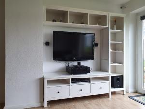 a white entertainment center with a flat screen tv at Hamburg/Berlin Hamburg App. 106 in Großenbrode