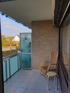einen Balkon mit einem Stuhl und einem Fenster in der Unterkunft Kajüte in Timmendorfer Strand