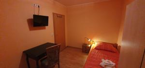 a small room with a bed and a table and a television at Ferienwohnung Wille in Lünen
