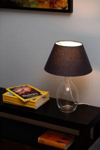 una lampada su un tavolo con una pila di libri di Apartment Warsaw Kredytowa by Renters a Varsavia