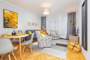 una sala da pranzo e un soggiorno con tavolo e sedie. di Apartment Warsaw Kredytowa by Renters a Varsavia