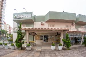 a building with potted plants in front of it at Pousada Brisa do Mar in Torres