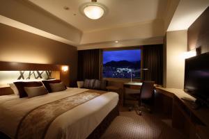 une chambre d'hôtel avec un lit, un bureau et une fenêtre dans l'établissement Hotel Metropolitan Nagano, à Nagano