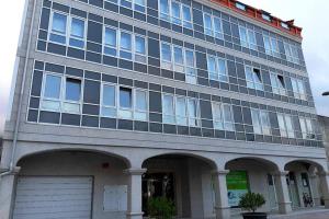 a large building with a garage in front of it at DISFRUTE DE SUS VACACIONES CON WIFI EN EL PUERTO DE CARIÑo in Cariño