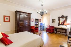 Palazzo Dalla Rosa Prati في بارما: غرفة نوم بسرير وطاولة وكراسي