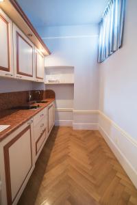 a kitchen with white cabinets and a wooden floor at Palazzo Dalla Rosa Prati in Parma