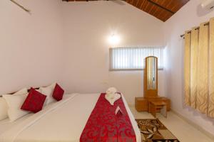a bedroom with a bed with a red blanket on it at KSTDC Hotel Mayura Velapuri Belur in Belūr +88 photos