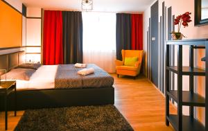 ウィーンにあるModern Suite Schönbrunnのベッドと椅子付きのホテルルーム