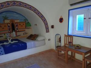 a bedroom with a bed and a desk and a table at Al Baeirat Hotel in Luxor