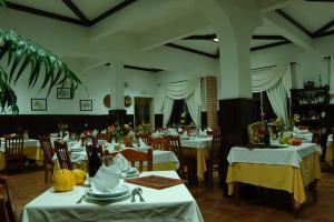 a dining room with white tables and chairs at A Moderna - Guest house Casa dos Serpas in Caldas da Felgueira