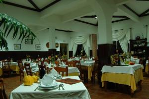 une salle à manger avec des tables et des chaises blanches dans l'établissement A Moderna - Guest house Casa dos Serpas, à Caldas da Felgueira