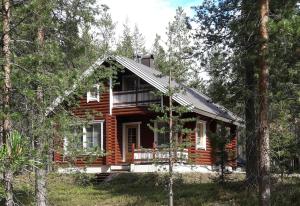 eine Blockhütte im Wald mit Bäumen in der Unterkunft Levi President Välirakka Chalet in Levi