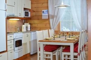 cocina con mesa con sillas y comedor en Levi President Välirakka Chalet, en Levi