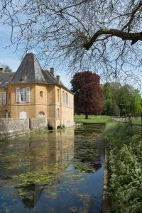 een huis met een vijver ervoor bij Château de Martigny 