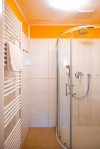 ウィーンにあるModern Suite Schönbrunnの白いタイル張りのバスルーム(シャワー付)