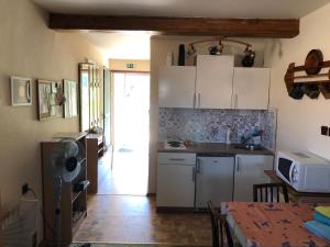 a kitchen with white cabinets and a table with a tableablish at Ubytování u Jeřábků in Mikulov