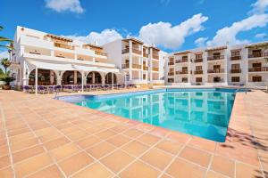 a swimming pool in front of a hotel at azuLine Apartamentos Can Sanso in Santa Eularia des Riu