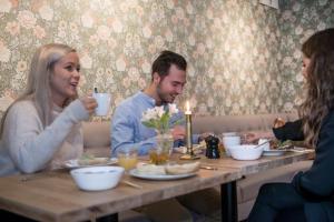 Un uomo e una donna seduti a un tavolo a bere caffè di Slottshotellet Annex a Kalmar
