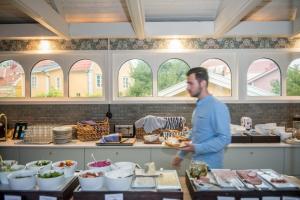 un hombre de pie en una cocina preparando comida en Slottshotellet Annex, en Kalmar