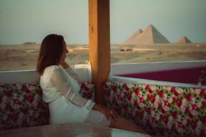a woman sitting on a train looking at the pyramids at Desert Moon in Cairo