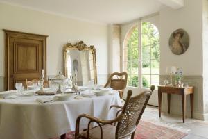 a dining room with a table and a mirror at Château de Martigny in Colmey