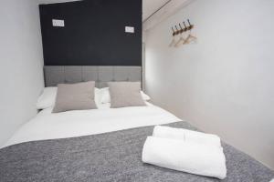 um quarto com uma grande cama branca e 2 almofadas em Cosy, modern annexe in Totnes em Totnes