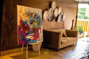 a living room with a painting and a couch at Roots Hotel Apartments Abidjan in Abidjan