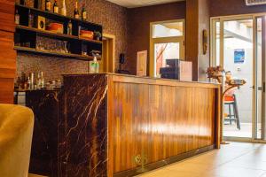 a bar with a wooden counter in a restaurant at Roots Hotel Apartments Abidjan in Abidjan