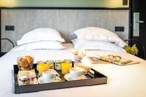 a tray of food sitting on top of a bed at Hotel de l'Aqueduc in Paris