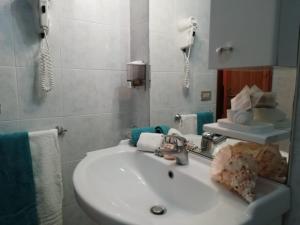a white sink sitting next to a bathroom mirror at Hotel Calabattaglia in Ventotene
