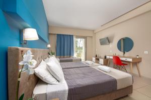 ein Hotelzimmer mit einem Bett und einem Schreibtisch in der Unterkunft Poseidon Beach Hotel in Laganas