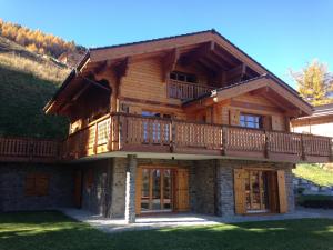 a large wooden house with a balcony on top at Croix Noires FABULOUS & LUXURY chalet 11 pers by Alpvision Résidences in Vex