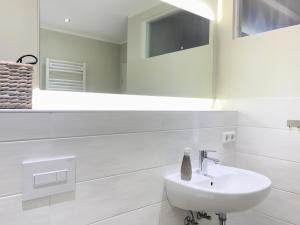 a white bathroom with a sink and a mirror at Spreewaldapartments-Kossatz in Lübben