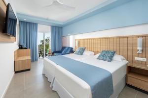 a hotel room with a large bed and a television at Hotel Riu Palace Palmeras - All Inclusive in Playa del Ingles