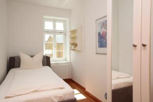 a bedroom with a bed and a window and a mirror at Gästehaus Schimmel´s in Wustrow