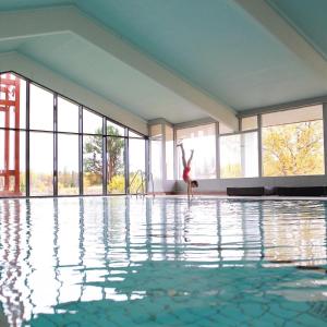 a woman is dancing in a swimming pool at Oset Fjellhotell in Gol