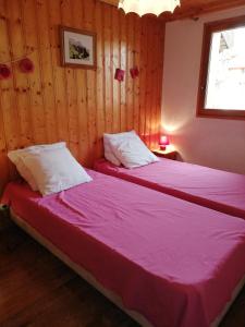 2 camas en una habitación con paneles de madera en appartement myosotis pour 10 personnes en Saint-Martin-de-Belleville
