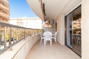 balkon z białymi krzesłami i stołem. w obiekcie UHC STELLA MARIS APARTMENTS w mieście Cambrils