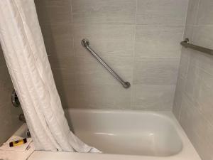 La salle de bains est pourvue d'une baignoire blanche avec rideau de douche. dans l'établissement Best Western Plus Regency Inn and Conference Centre, à Abbotsford