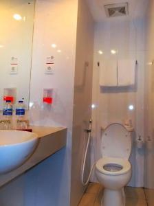 a bathroom with a white toilet and a sink at favehotel Kelapa Gading in Jakarta