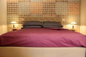 um quarto com uma grande cama rosa e 2 candeeiros em Atelier Musicale Suites em Roma